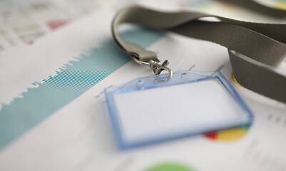 Close-up of empty paper in name tag. Document with colourful diagram and chart. Thing for person...