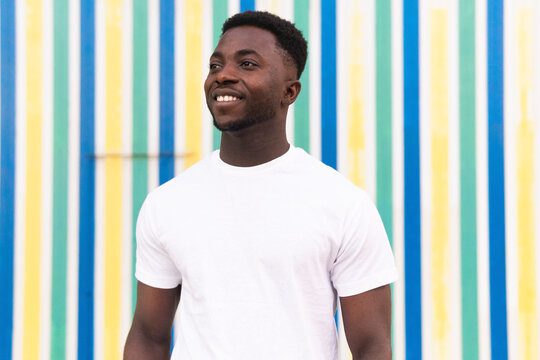 Cheerful black man against striped wall