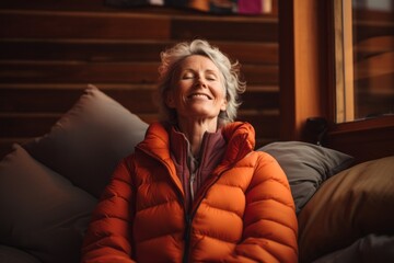 Portrait of a satisfied woman in her 60s sporting a quilted insulated jacket against a serene meditation room. AI Generation