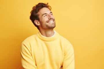 Fototapeta premium Portrait of a blissful man in his 30s dressed in a comfy fleece pullover against a pastel yellow background. AI Generation