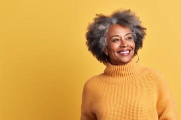 Portrait of a content afro-american woman in her 70s dressed in a warm wool sweater against a pastel yellow background. AI Generation