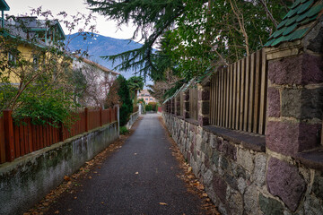 Eine schmale Gasse zwischen zwei Mauern mit einem Berg im Hintergrund