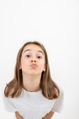 Funny teenage girlput her lips together for a kiss on a white background.
