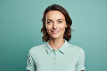 Portrait of a glad woman in her 30s donning a classy polo shirt against a pastel teal background. AI Generation