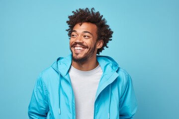 Fototapeta na wymiar Portrait of a cheerful afro-american man in his 30s wearing a functional windbreaker against a soft blue background. AI Generation