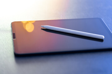 Digital tablet and stylus pen on the table close-up.