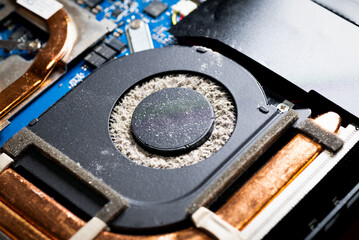 Dirty laptop computer fan is full of dust and needs cleaning.