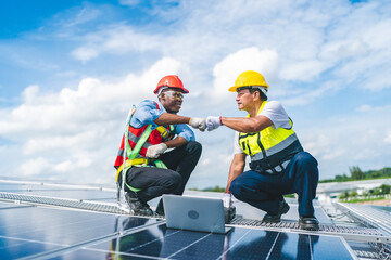 Engineer technician using laptop checking and operating system on rooftop of solar cell farm power...