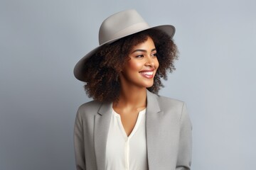 Portrait of a satisfied afro-american woman in her 20s donning a classic fedora against a soft gray background. AI Generation