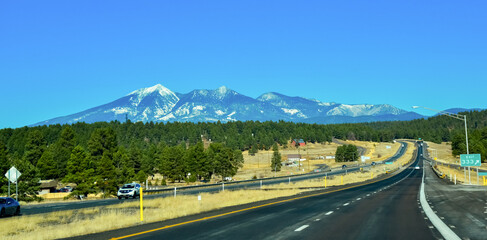 Naklejka premium Car road against the backdrop of snow-capped mountains in winter in Arizona