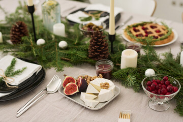 Closeup of treats put on festive table decorated with christmas tree branches