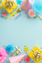 Festal birthday bash inspiration. Vertical top view capturing the festive ambiance with presents, hats, lollipops, balloons, and confetti on pastel blue background. Suitable for text or promo content