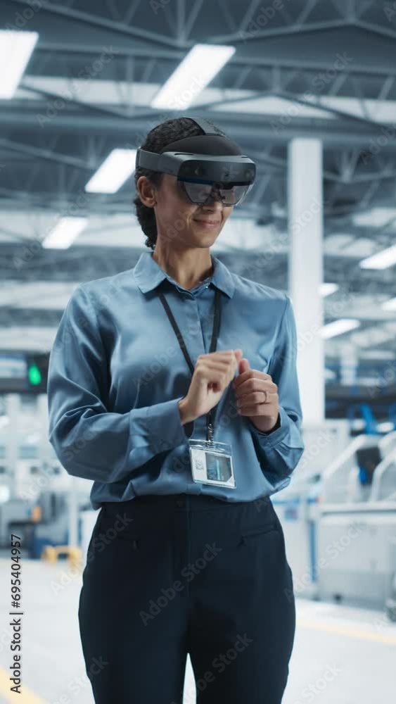 Aufkleber Vertical Screen: Hispanic Female Engineer Wearing an Augmented Reality Headset And Controlling Autonomous Production At an Electronics Factory. Technician Using Gestures To Configure Assembly Line.