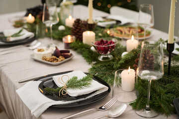 Plate decorated with fir branch displayed on festive christmas table fully prepared for celebration