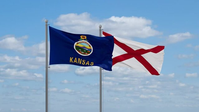 Alabama and Kansas US state flags waving together on cloudy sky, endless seamless loop