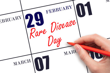 February 29. Hand writing text Rare Disease Day on calendar date. Save the date.