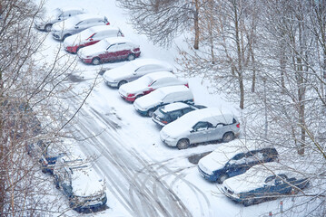 Cars buried in snow. Parked cars covered with snow during blizzard, view from above. Cars on snowy...