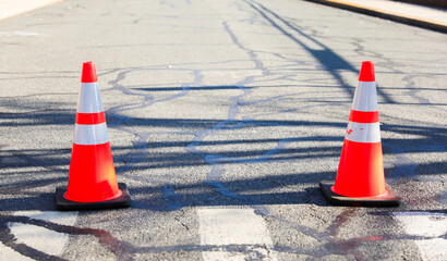 orange street construction cone on road with blurred background, symbolizing caution and ongoing...