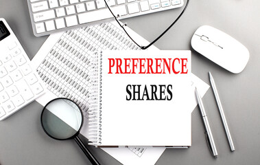 PREFERENCE SHARES text on notebook with keyboard and calculator on a chart background