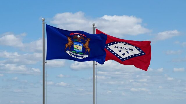 Arkansas and Michigan US state flags waving together on cloudy sky, endless seamless loop