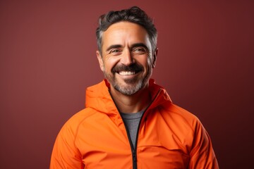 Portrait of a smiling man in his 40s wearing a windproof softshell against a vibrant yoga studio background. AI Generation