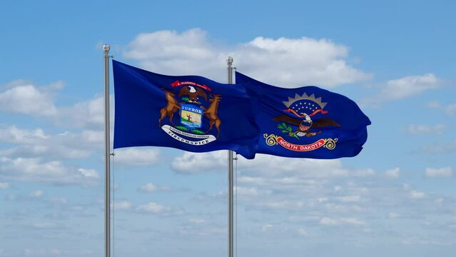 North Dakota and Michigan US state flags waving together on cloudy sky, endless seamless loop