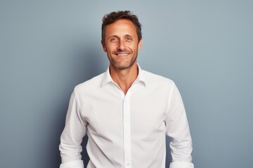 Portrait of a grinning man in his 40s wearing a classic white shirt against a pastel or soft colors background. AI Generation