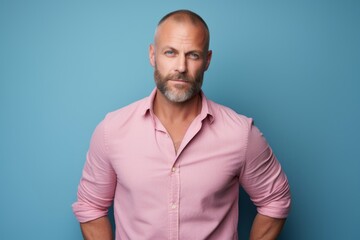 Fototapeta premium Portrait of a content man in his 40s sporting a versatile denim shirt against a pastel or soft colors background. AI Generation