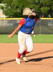 Girls softball players making athletic plays, throwing, sliding and catching the ball during a game