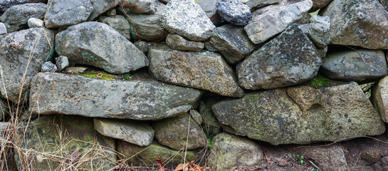 textured stone wall, showcasing rugged surface and natural patterns
