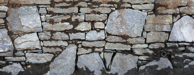 textured stone wall, showcasing rugged surface and natural patterns