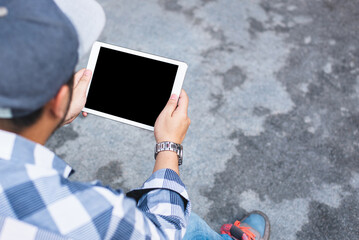 An isolated screen is displayed on a tablet computer held by a man in a mockup. View from above;...