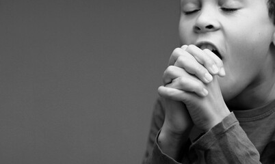 little boy praying to God with hands together with people stock image stock photo
