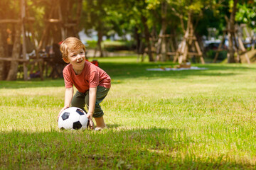 My son enjoys playing football in the backyard. Happy little child in nature in the park