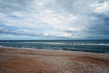 Awaiting the storm, a deserted beach stands patiently.