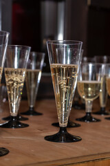 plastic Glasses of champagne on table bar. Buffet. Celebration of birthday, baptism, wedding or corporate party. Catering service. Serves glasses of sparkling wine.