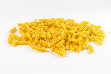 fusilli pasta lies on a white surface in a small pile