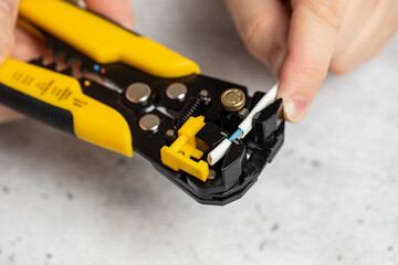 The use of the stripper cutter tool to strip the end of the electrical wire	