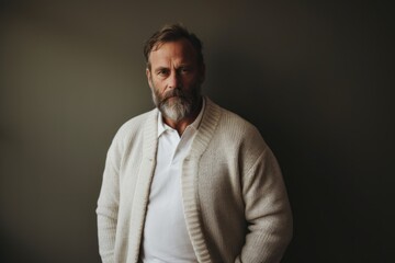 Fototapeta premium Portrait of a glad man in his 50s wearing a chic cardigan against a bare monochromatic room. AI Generation