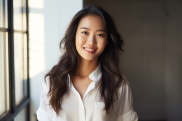 Portrait of a blissful asian woman in her 20s wearing a classic white shirt against a stylized simple home office background. AI Generation