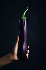 woman holding an eggplant in her hand to cook