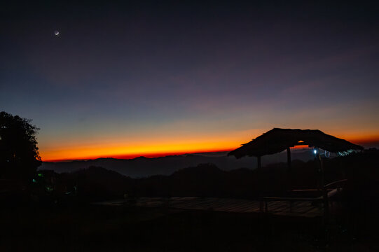 landscape view at civil twilight sunset with a crescent moon above