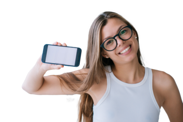 Cute caucasian young woman in glasses and white t-shirt holds phone shows blank screen looks at camera broad smiles stands against transparent background. Pretty female student