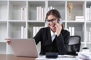 Young Asian woman using laptop to do financial transaction and plan finances and investments through online banking