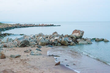 stone breakwaters on the sandy shore of the sea