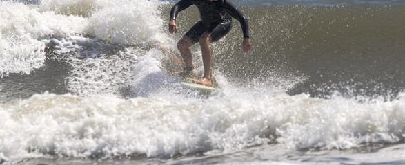 A man riding a wave on top of a surfboard in a very rough ocean