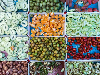 Top view of assorted fruits and pickled fruits on trays for sale in street market, healthy food concept Include high vitamin fruits, fresh fruits, Thai fruits, Street food.Variety fruits as background