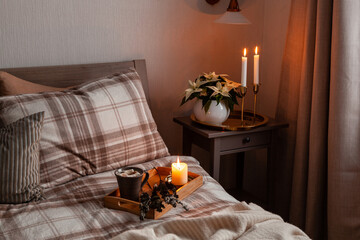 cozy scandinavian bedroom interior in natural tones, blanket candles houseplants