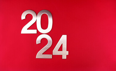 Composition with the number 2024 in silver, metal on a red monochrome background