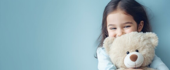 Smiling Young Girl with Teddy Bear on Blue Background - obrazy, fototapety, plakaty